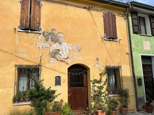 Anche Borgo San Giuliano è un borgo dai muri dipinti. La tradizione di decorare le case del borgo inizia durante la seconda edizione della Festa de’ borg, nel 1980: sui muri prendono vita i primi colori vivaci e i murales che raccontano i suoi abitanti e i paesaggi del porto e del mare, protagonista delle vite dei borghigiani. Nel 1994, con la scomparsa di Federico Fellini, la Festa de’ borg viene interamente dedicata al regista, in questa occasione pittori riminesi e non ritraggono le scene dei suoi film più famosi e i personaggi indimenticabili come Volpina, Scureza, Gelsomina… Voi avete mai visitato un borgo dai muri dipinti? #rimini #borgosangiuliano #emiliaromagna #rivieraromagnola #murales #streetart #muridipinti #italy #travel #travelblogger #travelblog #streetphotography #borghiitaliani #borghi #romagna #romagnamia #holiday #visit #tourist